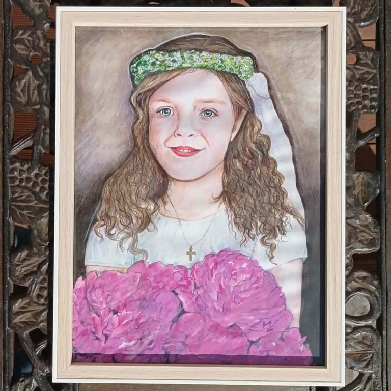 Portrait painting of a young girl with long wavy hair wearing a green flower crown and white shirt, holding pink flowers, framed in white